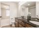 Bathroom featuring double sink vanity with dark countertop and an open doorway to the bedroom at 16016 Viking Lair Rd, Westfield, IN 46074