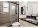Modern bathroom with a glass-enclosed shower, round mirror, and neutral tiling at 16016 Viking Lair Rd, Westfield, IN 46074