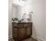 Bathroom vanity features a dark countertop, wood cabinetry, and decorative mirror at 16016 Viking Lair Rd, Westfield, IN 46074