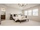 Bright bedroom featuring tray ceilings, a modern chandelier, and large windows for natural light at 16016 Viking Lair Rd, Westfield, IN 46074