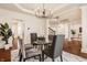 Dining area with modern chandelier, six chairs, open to foyer with staircase at 16016 Viking Lair Rd, Westfield, IN 46074