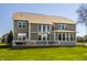 Back exterior view of a multi-story home with large windows, deck, and stone accents at 16016 Viking Lair Rd, Westfield, IN 46074