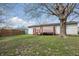 Spacious backyard with a deck, lush lawn, and mature tree at 1819 S Drexel Ave, Indianapolis, IN 46203