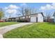 Well-maintained home with a brick accent, garage, and a lush green lawn at 1819 S Drexel Ave, Indianapolis, IN 46203
