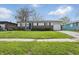 Charming single-story home featuring a brick facade, attached garage and well-maintained front lawn with mature trees at 1819 S Drexel Ave, Indianapolis, IN 46203