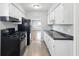 Efficient kitchen with black appliances, bright white cabinets, modern countertops and convenient access to the dining room at 1819 S Drexel Ave, Indianapolis, IN 46203