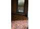 Retro carpeted bedroom shows wood paneling, a window, and remnants of past use at 1924 E Maryland St, Indianapolis, IN 46201