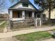Exterior view of an older home with a ramp leading to the front porch, boarded windows, and a chain-link fence at 1924 E Maryland St, Indianapolis, IN 46201
