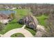 Aerial view of the stunning home, showcasing a large, manicured lawn, lake, and circular driveway at 1937 Knightsbridge Rd, Danville, IN 46122