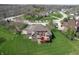 An aerial view showing a brick house with spacious backyard with patio, lush lawns, and mature trees at 1937 Knightsbridge Rd, Danville, IN 46122