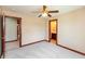 Neutral carpeted bedroom with ceiling fan, dark trim and view to adjacent bathroom at 1937 Knightsbridge Rd, Danville, IN 46122