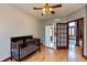 A Bedroom with a wood crib, neutral walls, and a glass-paneled door leading to the living area at 1937 Knightsbridge Rd, Danville, IN 46122