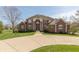 Attractive brick home with a wide driveway, a large lawn, and manicured landscaping, offering great curb appeal at 1937 Knightsbridge Rd, Danville, IN 46122