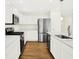 Contemporary kitchen with white cabinetry, stainless steel appliances, wood floors, and quartz countertop island at 19602 Atwater Ave, Sheridan, IN 46069