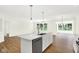 Open kitchen featuring a central island, wood floors and a view to the outdoors through large windows at 19602 Atwater Ave, Sheridan, IN 46069