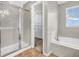 This bathroom boasts a glass door shower, tub, and walk-in closet, offering convenience and space at 1968 Saratoga Dr, Greenwood, IN 46143