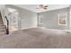 Spacious living room featuring neutral walls, plush carpet, ceiling fan, and ample natural light from multiple windows at 1968 Saratoga Dr, Greenwood, IN 46143