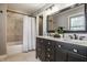 Modern bathroom with a double sink vanity, a tiled shower with a curtain, and a large mirror at 1995 W 116Th St, Carmel, IN 46032