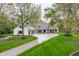 Elegant home showcasing a circular driveway, manicured lawn, stone accents and a three car garage at 1995 W 116Th St, Carmel, IN 46032
