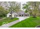 Elegant home showcasing a circular driveway, manicured lawn, stone accents and a three car garage at 1995 W 116Th St, Carmel, IN 46032