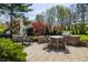 Outdoor kitchen and dining area with paver patio and lush landscaping perfect for outdoor entertaining at 1995 W 116Th St, Carmel, IN 46032