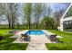 Backyard pool with lounge seating for relaxation and mature trees create a private oasis at 1995 W 116Th St, Carmel, IN 46032