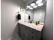 Stylish bathroom featuring a gray vanity with a granite countertop, updated fixtures, and modern finishes at 21 Osage Ct, Columbus, IN 47201