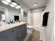 Modern bathroom with gray vanity, granite countertop, updated fixtures, and a shower-tub combination at 21 Osage Ct, Columbus, IN 47201