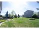 Spacious backyard featuring a lush lawn, patio with umbrella, and mature trees, perfect for outdoor entertaining at 2261 Mustang Chase Dr, Carmel, IN 46074
