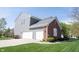 Side view of a two-story home featuring brick facade and three-car garage at 2261 Mustang Chase Dr, Carmel, IN 46074