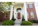 Inviting front entrance with a red door, decorative wreath, and well-maintained landscaping, enhancing curb appeal at 2261 Mustang Chase Dr, Carmel, IN 46074