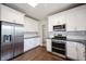 Well-lit kitchen with stainless appliances, dark countertops, and white cabinets at 2261 Mustang Chase Dr, Carmel, IN 46074