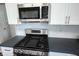 Close up of new stainless steel gas range and microwave with shaker cabinets at 2261 Mustang Chase Dr, Carmel, IN 46074