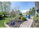 Inviting patio area with firepit, Adirondack chairs, and lush landscaping at 2261 Mustang Chase Dr, Carmel, IN 46074