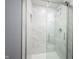 Walk-in shower with glass doors showcases marble-look walls and a built-in shelf at 2261 Mustang Chase Dr, Carmel, IN 46074