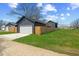 View of garage with a white garage door, surrounded by a wooden fence and grass at 2325 E Brookside Ave, Indianapolis, IN 46218