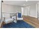 Hallway features hardwood floors, two chairs with a blue rug, and three doors at 2325 E Brookside Ave, Indianapolis, IN 46218