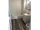 Bathroom with tub, sink, toilet and modern wood look floors at 2413 N Macedonia Ave, Muncie, IN 47303