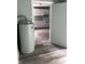 A utility room with a water heater is next to a room with white kitchen cabinets at 2413 N Macedonia Ave, Muncie, IN 47303
