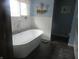 Luxurious bathroom featuring a modern soaking tub, stylish fixtures, and wainscoting details at 2427 Cedar Bend Dr, Anderson, IN 46011
