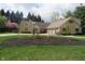 Well-maintained exterior featuring stone accents, manicured lawn, landscaping and basketball hoop at 2427 Cedar Bend Dr, Anderson, IN 46011