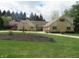 Well-maintained exterior featuring stone accents, manicured lawn, landscaping and basketball hoop at 2427 Cedar Bend Dr, Anderson, IN 46011