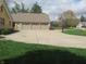 Spacious three-car garage with a long driveway, basketball hoop and well-maintained lawn at 2427 Cedar Bend Dr, Anderson, IN 46011