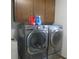 Modern laundry room with new washer and dryer set and overhead cabinetry at 2427 Cedar Bend Dr, Anderson, IN 46011