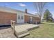 Backyard view of a home with a brick facade, a wood deck, and a chain-link fence at 2526 David Dr, Westfield, IN 46074