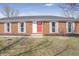 A closer view of the red front door and white-framed windows on this inviting brick home at 2526 David Dr, Westfield, IN 46074