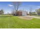 Exterior side view of a brick home with a detached garage, green lawn and trees at 2526 David Dr, Westfield, IN 46074