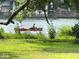 Scenic waterfront view featuring a red canoe gliding on the water, surrounded by lush greenery at 256 Riverwood Dr, Noblesville, IN 46062