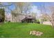 Spacious backyard featuring lush green grass and a charming fire pit with a view of the home's exterior at 2601 Fairhaven Dr, Indianapolis, IN 46229