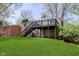 Home's back exterior view with upper deck, stairs to green yard and home's siding at 2601 Fairhaven Dr, Indianapolis, IN 46229